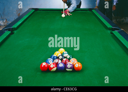 Rack di sfere pool impostare sul tavolo e uomo giocando con la bilia battente Foto Stock