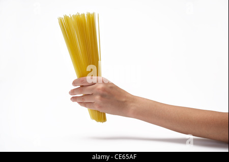 Donna di mano azienda mazzetto di spaghetti. Isolato su uno sfondo bianco. Foto Stock