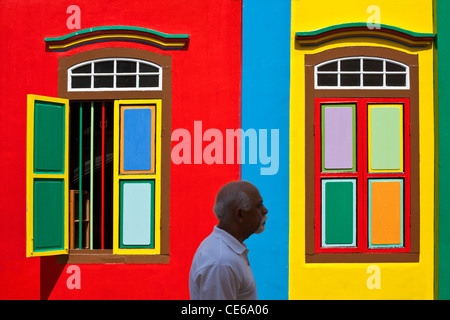 Uomo che cammina passato un patrimonio colouful edificio in Little India, Singapore Foto Stock