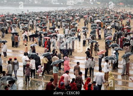 Persone in piedi in monsone pioggia con ombrelloni aperti a Chowpatty Beach ; Bombay ; Mumbai ; Maharashtra ; India ; Asia Foto Stock