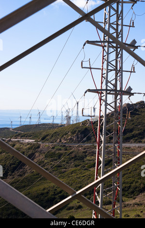 Guardare attraverso il palo elettrico al paesaggio con turbine eoliche. Tarifa, Cadice, Andalusia, Spagna. Foto Stock