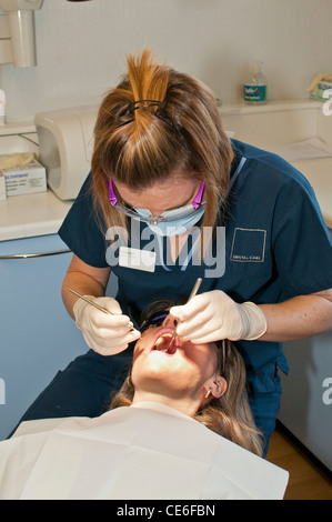 Dental hygenist pulizia di denti poltrona del dentista pulire hygene controllo check up ragazza bianco caucasico check up Foto Stock