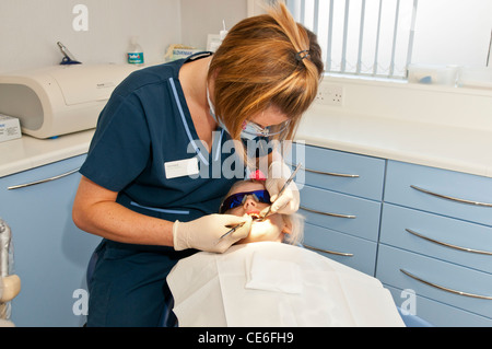 Dental hygenist pulizia di denti poltrona del dentista pulire hygene controllo check up ragazza bambino " cinque " anni di riempimento cauc cinque Foto Stock