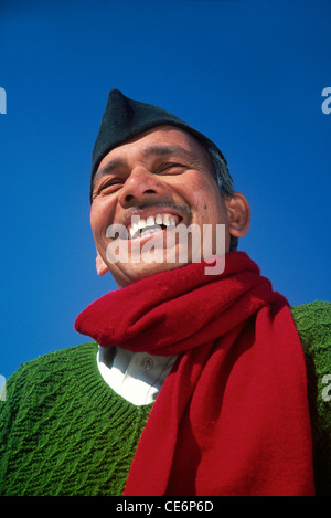 Uomo di ridere che indossa un maglione verde sciarpa rossa camicia bianca cappello nero contro il cielo blu India Signor#542 Foto Stock