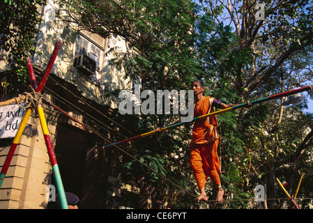 Donna acrobat bilanciamento sulla corda street performance ; Mumbai Bombay ; maharashtra ; India Foto Stock