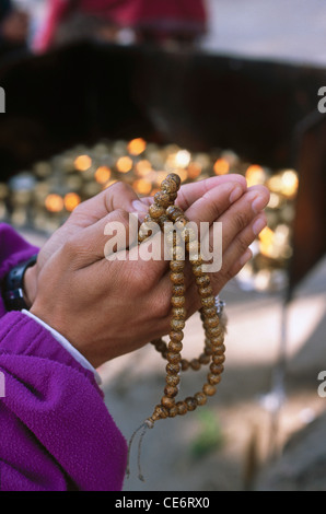 HMA 87804 : mano che tiene il salmodiare mala rosario tempio syambhunath Kathmandu in Nepal Foto Stock