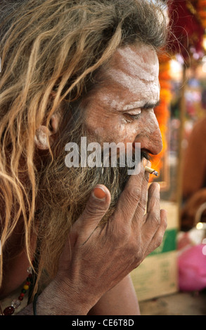 RSC 85887 : sadhu lunghi capelli aggrovigliati di fumare bidi in fiera di Pushkar Rajasthan in India Foto Stock