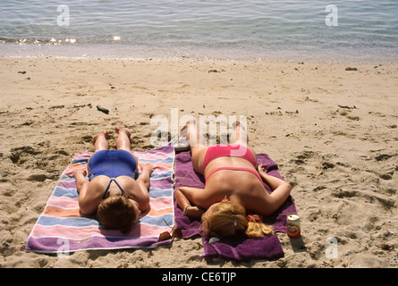 HMA 85968 : due donne sole rilassante costume blu e rosso costume da bagno sulla spiaggia india Foto Stock