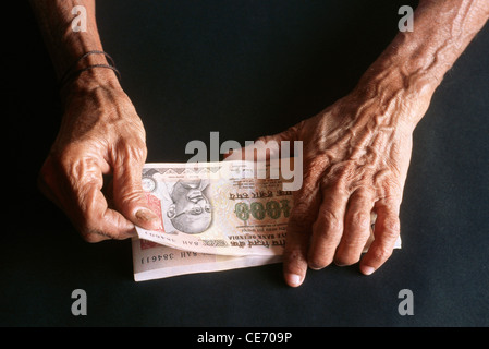 Vecchia donna conteggio carta moneta 1000 mille rupie indiane note Foto Stock