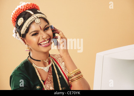 RMM 84072 : South Asian Indian lady donna bharatnatyam ballerina entusiasti di parlare il telefono cellulare seduti nella parte anteriore del computer signor#579 Foto Stock