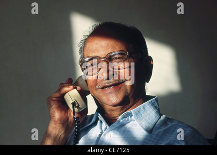 Anziano indiano che indossa occhiali che parlano al telefono ; India ; Asia ; MR 320 Foto Stock
