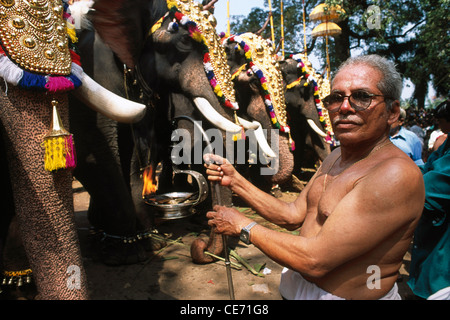 Trichur pooram festival uomo con lampada pregando davanti di elefanti prima processione di Festival di thrissur kerala india Foto Stock