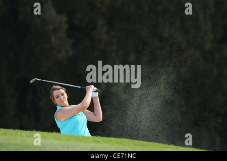 Giocatore di golf femminile giocando Bunker Shot Foto Stock