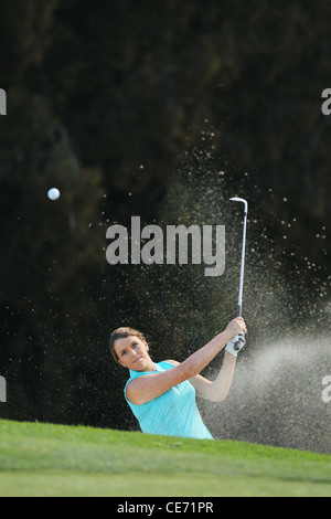 Giocatore di golf femminile giocando Bunker Shot Foto Stock