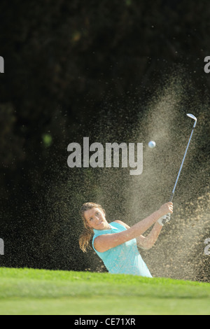 Giocatore di golf femminile giocando Bunker Shot Foto Stock