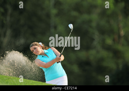 Giocatore di golf femminile giocando Bunker Shot Foto Stock