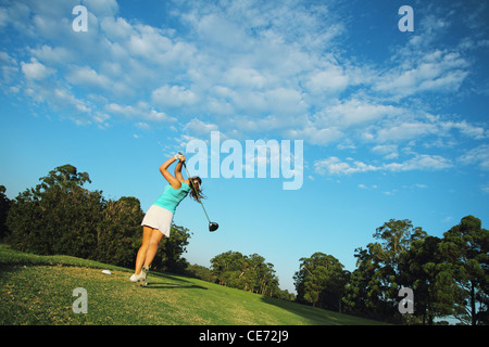 Giovane donna di colpire conducente tiro dal tee da golf Foto Stock