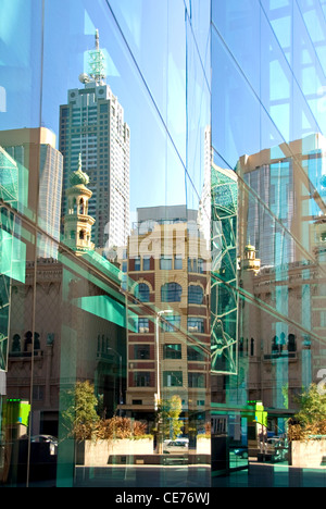 Riflessioni e nelle vicinanze degli edifici adiacenti nella facciata di vetro di un inner-city building, Melbourne, Victoria, Australia Foto Stock