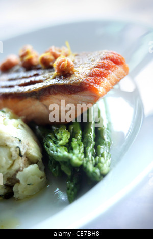 PAN FRIED FILETTO DI SALMONE CON SCHIACCIATO JERSEY ROYALS, asparagi e gamberetti burro Foto Stock