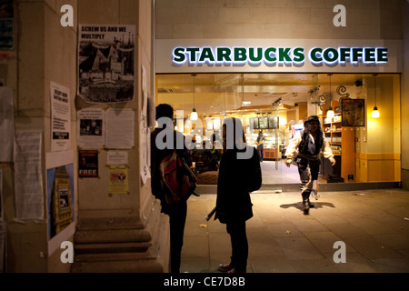 Manifesti di protesta da san Paolo professione camp sono visti al di fuori del caffè Starbucks. Foto Stock