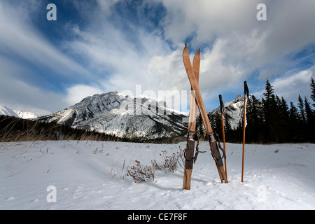 Vintage gli sci sulla neve con le montagne e le nuvole in background Foto Stock