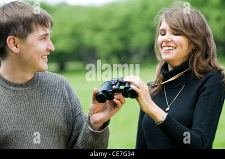 Felice coppia giovane avendo divertimento con il binocolo Foto Stock