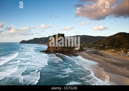 Piha Beach e Lion Rock al tramonto. Piha, Waitakere gamme Parco Regionale, Auckland, Isola del nord, Nuova Zelanda Foto Stock