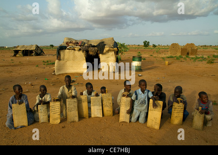 Rifugiato sudanese di bambini per un aria aperta la scuola con i notebook legno Sudan Darfur Foto Stock