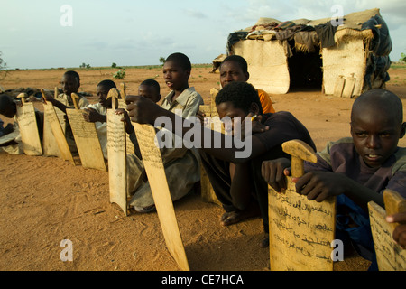 Rifugiato sudanese di bambini per un aria aperta la scuola con i notebook legno Sudan Darfur Foto Stock