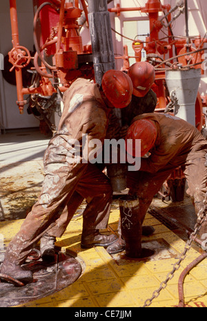 Azione Roughneck con tubo di trivella sulla piattaforma della torre di perforazione di una prospezione piattaforma petrolifera nel Mare Rosso off costa egiziana. Foto Stock