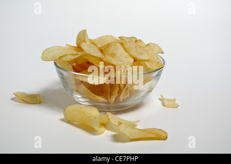 Potato Chips sedersi in una ciotola di vetro su uno sfondo bianco. Foto Stock