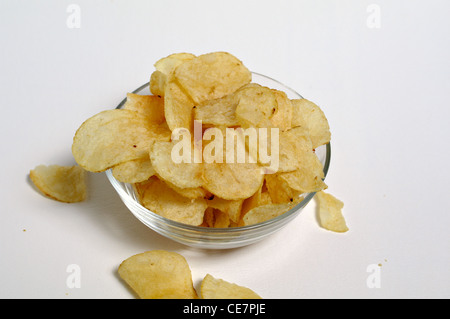 Potato Chips sedersi in una ciotola di vetro su uno sfondo bianco. Foto Stock