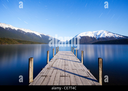 Il molo al Lago Rotoiti, Nelson Lakes National Park, Nuova Zelanda, al chiaro di luna. Tracce stellari si possono vedere nel cielo. Foto Stock