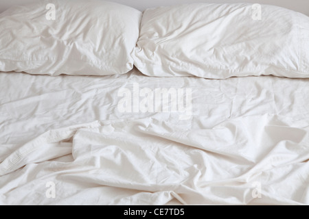 Letto vuoto con disheveled i cuscini e le lenzuola Foto Stock