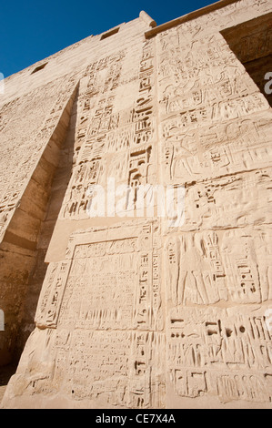 Geroglifico egizio sculture e dipinti sul muro del tempio antico al Medinat Habu a Luxor Foto Stock