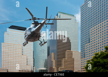 Un elicottero che vola tra la scyscraper del sud di Manhattan Foto Stock