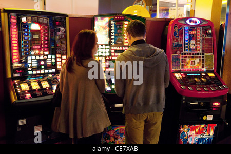 Una giovane coppia giocando sulle slot machine nel divertimento arcade, Cambridge Regno Unito Foto Stock