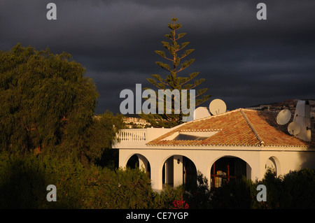 Villa spagnola con nuvole scure, Calypso, Mijas Costa, provincia di Malaga, Costa del Sol, Andalusia, Spagna, Europa occidentale. Foto Stock