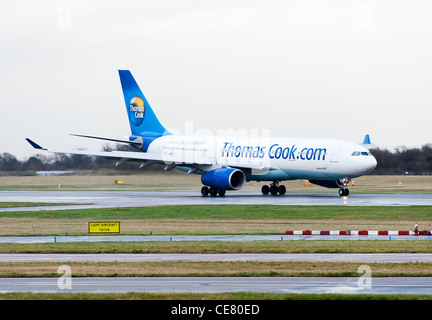 Thomas Cook Airlines Airbus A330-243 aereo di linea G-OMYT atterraggio all'Aeroporto Internazionale di Manchester sulla un Wet gennaio giorno England Regno Unito Foto Stock