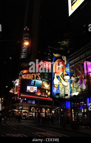 Notte ritratto al neon M&M mondo negozio di caramelle, West 48th Street, verso Hershey Store su Broadway, 7th Avenue, New York Foto Stock