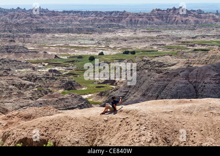 American National Park Badlands South Dakota SD un youg man scatta foto della montagna in movimento vista posteriore orizzontale Stati Uniti alta risoluzione Foto Stock