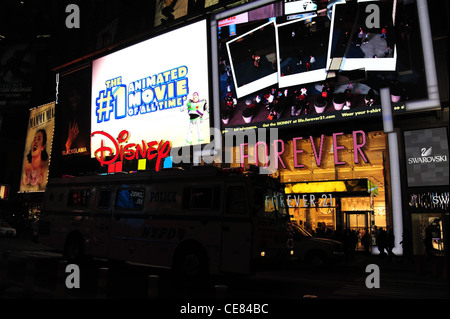 Di notte il neon cartelloni view double deck bus passando Disney Store, Forever 21 Boutique Store, 7th Avenue, Times Square, New York Foto Stock