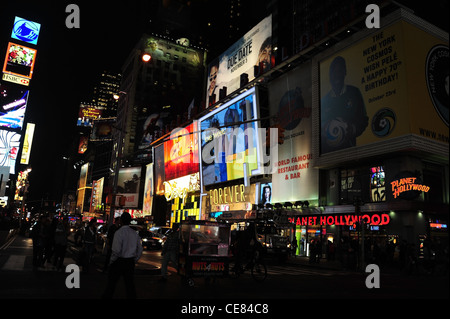 Notte Vista al neon, verso Piazza Duffy, persone, Planet Hollywood Forever 21, Disney Store, 7th Avenue, Times Square, New York Foto Stock