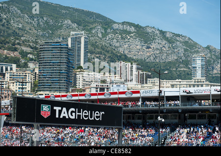 La folla di spettatori a guardare il 2011 Grand Prix di Monaco, con la città e le montagne sullo sfondo Foto Stock