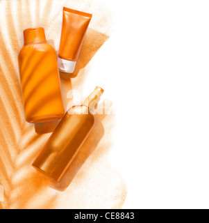 Sunscreen contenitori in un ambiente tropicale su un fondo sabbioso Foto Stock