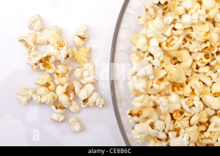 Il popcorn in recipiente di vetro su sfondo bianco Foto Stock