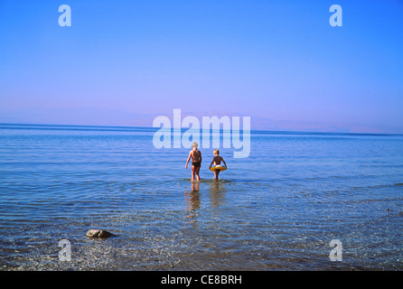 Due bambini a piedi nel mare di Galilea (lago di Tiberiade), Israele Foto Stock