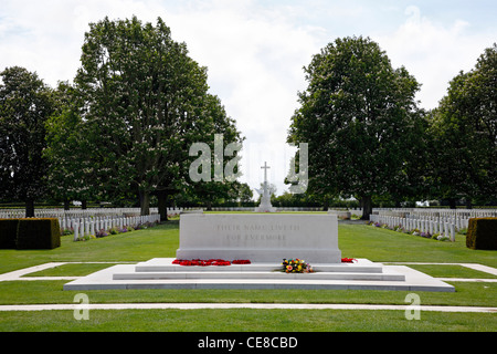 Memorial con fiori e la croce del sacrificio nella distanza presso il British Bayeux Cimitero di guerra, di Bayeux in Normandia, Francia. Il cimitero militare. Foto Stock