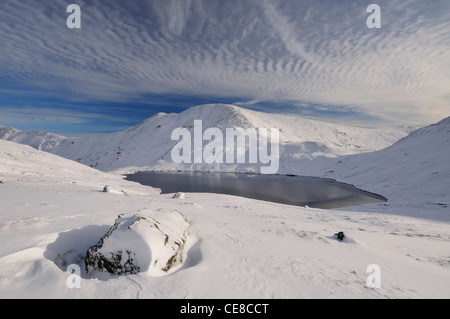 Grisedale Tarn e Fairfield sotto una copertura di neve in inverno nel Lake District inglese Foto Stock