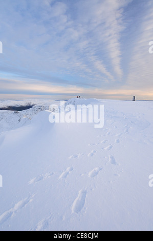 Footprint e cornicioni sulla coperta di neve il vertice di Helvellyn nel Lake District inglese Foto Stock